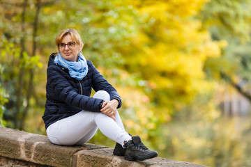 Wall Mural - Middle-aged woman resting in city park