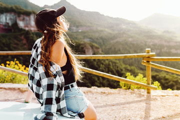 Wall Mural - Beautiful young woman enjoying nature at mountain peak.