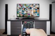 © Proxima Studio - Watching television in modern TV room. Hand holding remote