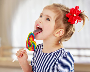 Girl licks candy on a stick