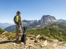 Young Beautiful Woman Enjoying The View With Her Dog During Hiki