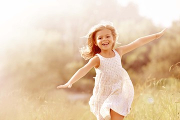 little girl running in country field in summer