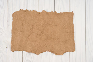 Crumpled paper on a white wooden background.