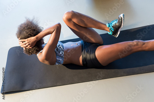 Fotografie, Obraz smiling young woman working out at fitness center doing crunch a
