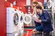Couple Choosing Washing Machine At Hypermarket