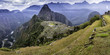 Panoramic shot of the lost Inca city of Machu Picchu with yellow grassland, clouds and Huayna Picchu in the background.