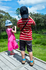 Wall Mural - Back view of asian children relaxing outdoors in the day time