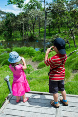 Wall Mural - Back view of asian children relaxing outdoors in the day time