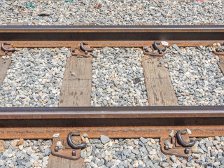 The closeup of an old railway tracks with wood and gravel