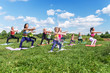 © undrey - Group of women exercising and doing squats at boot camp.