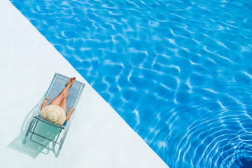 Sticker - beautiful woman in a hat sitting on the edge of the pool