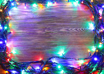 Wall Mural - Christmas lights on a wooden background