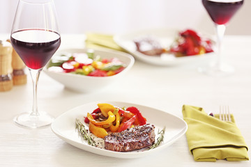 Poster - Tasty steak with fried vegetables on dinner table