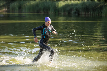 Wall Mural - Sportive girl runs on the water