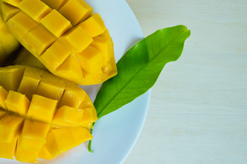 Mango nicely cut with leaf on wooden background (Also known as h