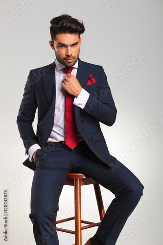 Fotografía Sentado elegante hombre de negocios la fijación de su corbata