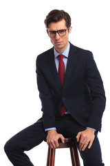 Wall Mural - relaxed young business man wearing glasses is sitting