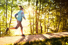 Woman Running In Park During Sunny Morning