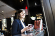 © Astrakan Images - Smiling businesswoman with smartphone and laptop at coffee shop