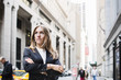 © Astrakan Images - Close-up of confident businesswoman with arms crossed standing against building