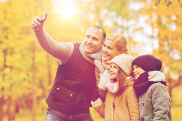 Wall Mural - happy family with camera in autumn park