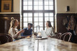 © Astrakan Images - Friends sitting at large table and talking