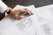 © Astrakan Images - Cropped image architect working on blueprint at table in office