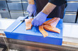 © Astrakan Images - Midsection of fish vendor cutting salmon at refrigerated section in supermarket