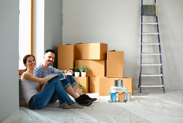 Young happy couple sitting floor in the new home