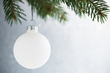White Christmas Ball On The Xmas Tree On Glitter Bokeh Background. Merry Christmas Card. Winter Holidays. Xmas Theme. Happy New Year.