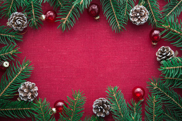 Wall Mural - frame with xmas tree and ornaments on red canvas background. merry christmas card. winter holiday th