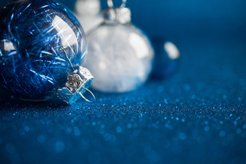 Wall Mural - white and blue christmas ornaments on dark blue glitter background with space for text. merry christ