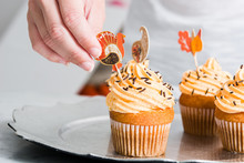Woman Preparing Delicious Thanksgiving Cupcakes