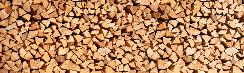 Wall Mural - panoramic photo of a stack of wood logs for winter, wooden header, abstract background