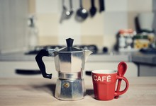 Red Coffee Cup And  Vintage Coffeepot On Kitchen Stove