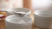 Measuring Teaspoon Of Baking Powder Into Mixing Bowl