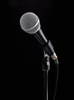 © rgvc - Microphone on stand against a black background