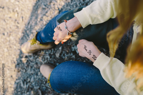 Fotografie, Obraz cropped image of a hands of a young woman with the Mehndi inscriptions "Viva la Vida" and treble clef sign