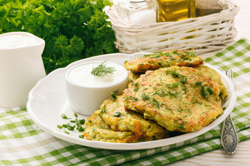 Wall Mural - Fritters with zucchini and carrots on white wooden background.