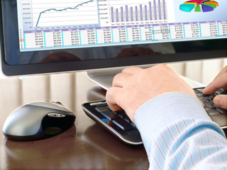 Fototapete - Male Hands on the Keyboard in Front of Computer Screen with Charts

