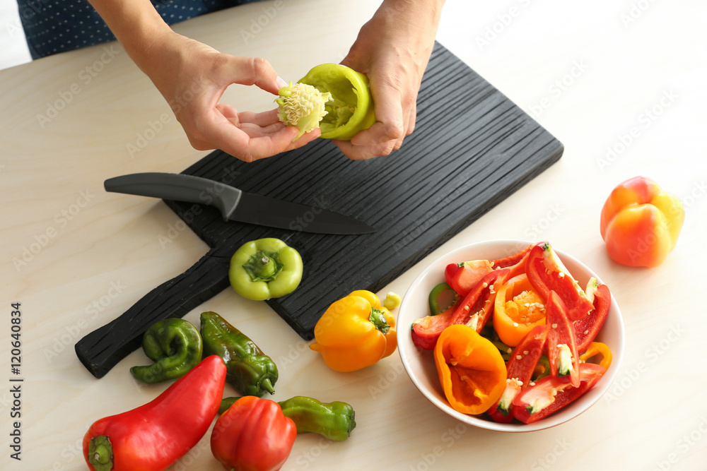 Woman preparing peppers in kitchen