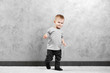 © Africa Studio - Fashionably dressed baby boy posing on a gray wall background