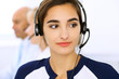 © rogerphoto - Call center. Focus on beautiful woman in headset