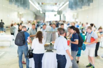 Abstract blurred people socializing during buffet lunch break at business meeting or conference.