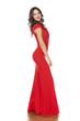 young beautiful woman posing in a long red dress on a white background