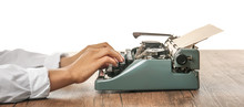 Man Working On Retro Typewriter At Desk On White Background
