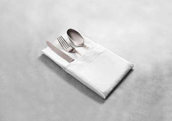 Blank white restaurant cloth napkin mock up with silver cutlery set, isolated. Knife fork and spoon in clear textile towel mockup template. Cafe branding identity clean napkin surface for logo design.