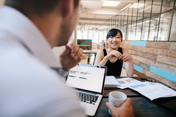 Two business colleagues discussing work in office