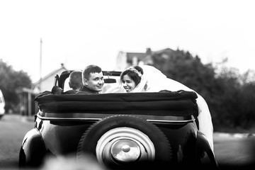 Wall Mural - beautiful and young couple sitting in wedding convoy