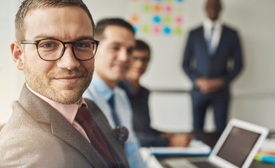 Canvas Print - Cute man in eyeglasses with co-workers in meeting